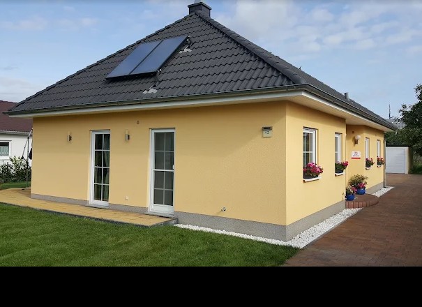 Musterhaus Berlin-Altglienicke – gelber Bungalow mit dunklem Ziegeldach
